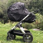 regntrekk med myggnett til barnevogn fra tinkafu på stokke bagdel